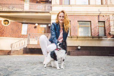 Tema evcil hayvanla yürümek. Avrupa 'daki eski bir evde tasmalı beyaz kadın ve chihuahua köpeği. Sahibi ile köpek chihuahua. Konu, insan ve hayvanın arkadaşlığı..