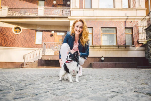 Woman and dog. Outside, happy. theme is the friendship of man and animal. Girl with chihuahua. young woman and her dog chihuahua outdoors walking by the street. dog pulling on leash.