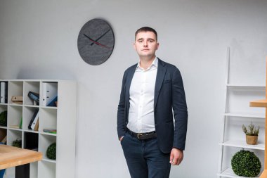 Ofiste takım elbiseli şişman bir işadamı. İş yerindeki şişman iş adamı. Başarılı, iri yarı, siyah takım elbiseli bir işadamı ofiste duruyor. Ofisteki aşırı kilolu iş konusu.
