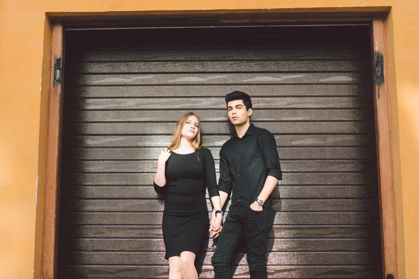 穿着黑色衣服的多种族时髦夫妇在木墙的背景上摆姿势 土耳其男人和高加索女人约会和恋爱 生活时尚的一对恋人 年轻又自由 — 图库照片