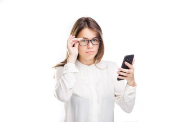 Kafkasyalı genç iş kadınının portresi beyaz arka planda akıllı telefon kullanıyor. İzole et. Ofis elbiseli bir kadın telefona bakıyor, elinde cep telefonu tutuyor. Tema İş ve Teknoloji.