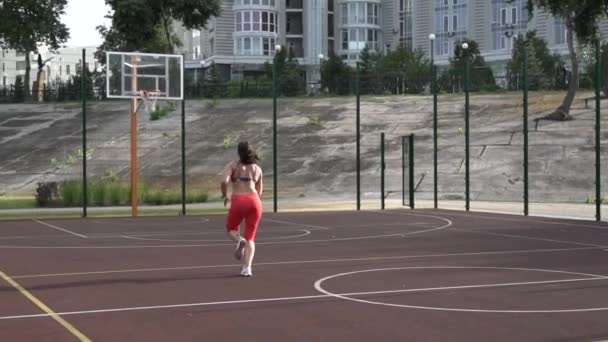 Dayanıklılık için ara hız eğitimi. Bir kadın basketbol sahasında hız koşusu yapıyor. Kadın koşuyor, koşuyor. Kışın açık havada koşan kadın sporcu. — Stok video