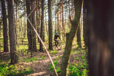 Kirlilik maskesi takan bisikletçi. Solunum cihazındaki 2.5 numaralı filtreyle parka bisikletle giden genç adam. Covid 19 Karantina Sporu. Dağ bisikletçisi ormanda bisiklet sürüyor. Bir patikada dağ bisikleti sürücüsü.