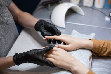 Güzellik salonu, müşteri ellerine nemlendirici krem sürmek ve masaj yapmak. Kuaförde manikür. SPA manikürü, el masajı ve vücut bakımı. Kapatın. Yumuşak ten. Kozmetik bilimi, uygulama.