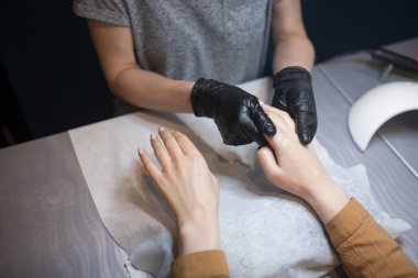 Güzellik uzmanı, müşteri ellerine krem sürüyor. Güzellik salonu. El masajı. Kuaförde manikür. Spa Manikür konsepti. Narin manikürlü ve nemlendirici kremli kadın elleri. Yumuşak ten. El, güzellik..
