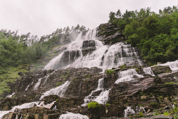 view of Tvindefossen or Tvinnefossen waterfall near Voss, Norway. Natural, landscape. Tvinde Camping. Marquee, rocks