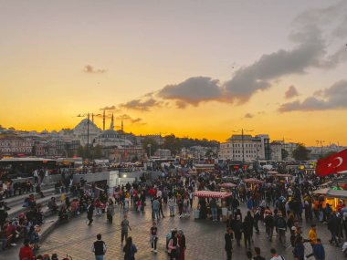 27 Ekim 2019. Eminonu Meydanı gün batımında, İstanbul 'da, Türkiye' de. Türkiye 'de Galata Köprüsü yakınlarındaki bir meydanda, İstanbul' da alışveriş ve tarihi varış noktasında insanlar dinleniyor ve sosyalleşiyor.