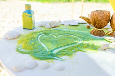 Gelin ve damat, Dominik Cumhuriyeti 'nin Punta Cana kentindeki okyanusun önündeki kumlu sahil nikah töreninde kristal vazoya renkli farklı renkte kumlar döküyorlar.