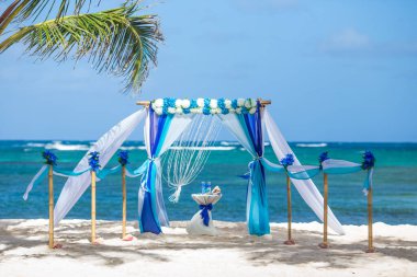 Dominik Cumhuriyeti 'ndeki düğün merasimi için güneşli bir günde kumsalda taze çiçek desenli bambudan yapılmış renkli düğün kemeri çardağı.  