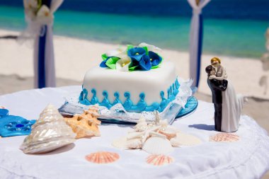 Tropical wedding cake for bride and groom to cut during destination wedding marriage outdoor ceremony on the sandy beach in Dominican republic  clipart