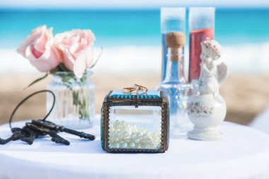 Alyanslar, Dominik Cumhuriyeti, Punta Cana 'daki kumlu kumsalda tropikal Karayipler için düzenlenen düğün aksesuarlarıyla donatılmış.