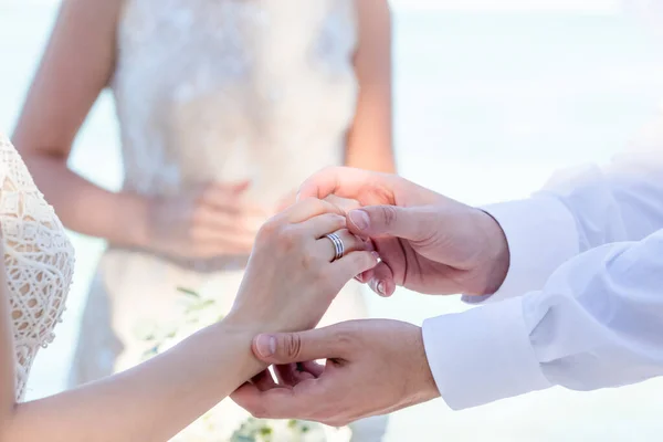 ドミニカ共和国プンタ カナの海の前の砂浜で象徴的な海上装飾の目的地の結婚式の結婚指輪を交換する花嫁と新郎 — ストック写真