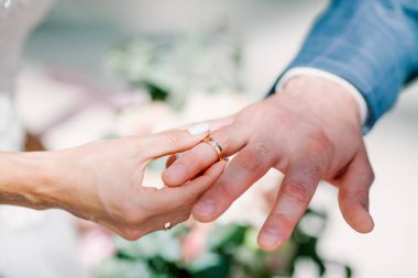 Gelin ve damat, Dominik Cumhuriyeti, Punta Cana 'da okyanusun kıyısındaki kumsalda deniz manzaralı düğün sırasında yüzüklerini değiş tokuş ediyorlar.  