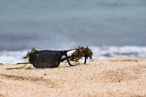 Óculos de sol quebrados na praia de areia — Fotografia de Stock