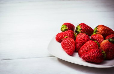 uçan daire beyaz tahtalar üzerinde üzerinde kırmızı olgun çilek