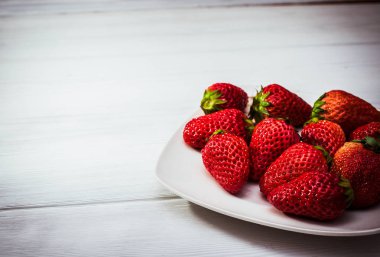 uçan daire beyaz tahtalar üzerinde üzerinde kırmızı olgun çilek