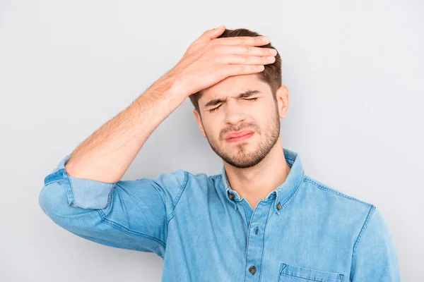 Portrait of overworked sad man with headache on gray background — Stock Photo, Image