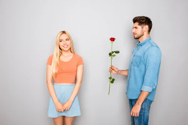 Jeune homme présentant rose rouge à sa petite amie — Photo