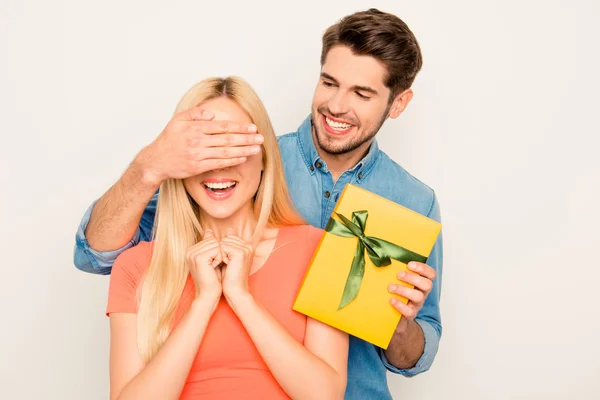 Surprise! Happy guy closing eyes of his girlfriend and holding y — Stock Photo, Image