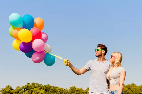 男人和女人在爱抱着五颜六色的气球的肖像 — 图库照片