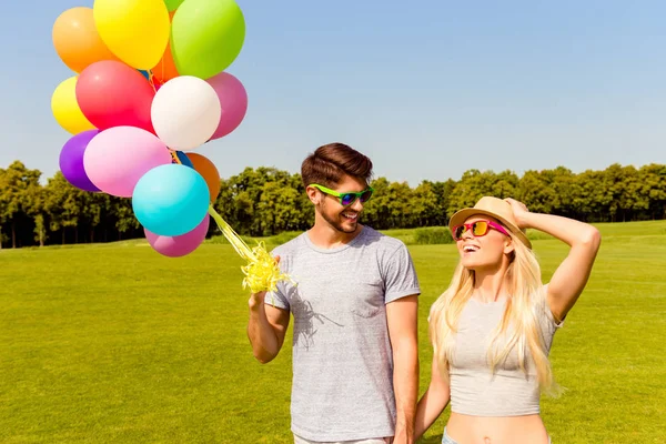 快乐的年轻夫妇在爱着五颜六色的气球，在公园里 — 图库照片