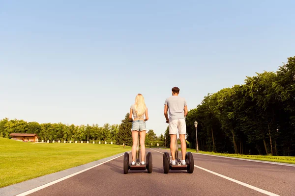 男と女が公園でセグウェイに乗っての背面図 — ストック写真