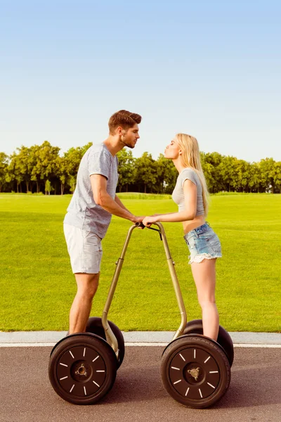 Retrato de dos amantes felices de pie en segways e ir a ki —  Fotos de Stock