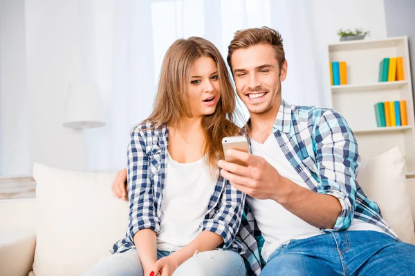 Усміхнений чоловік показує свій новий мобільний телефон своїй дружині — стокове фото