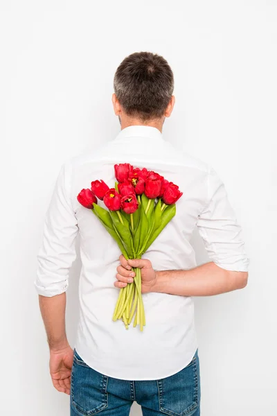 チューリップの花束を持ってロマンチックな男の背面図 — ストック写真