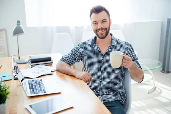 Glücklicher junger Geschäftsmann, der am Arbeitsplatz Pause macht und Kaffee trinkt — Stockfoto