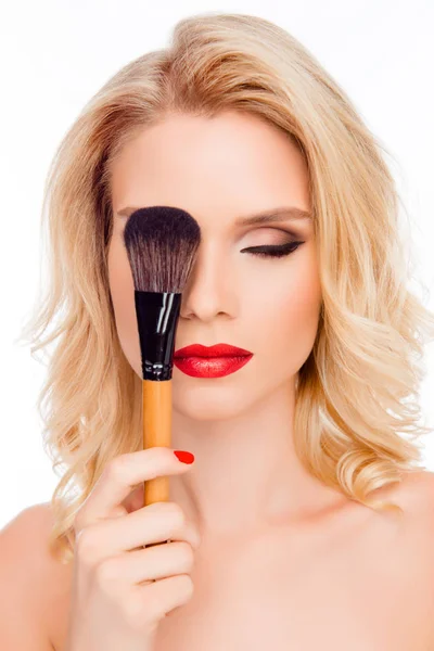 Sexy bonita loira escondendo olho atrás da escova de maquiagem — Fotografia de Stock