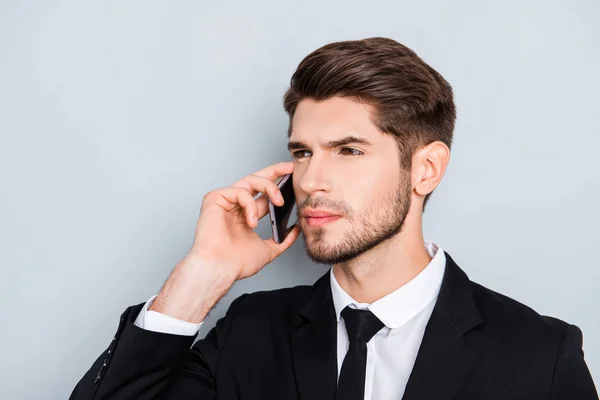 Молодой серьезный бородатый бизнесмен говорит о телефоне с коллегой — стоковое фото
