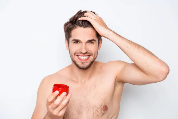 Cheerful happy young man applying wax on his hair — Stock Photo, Image