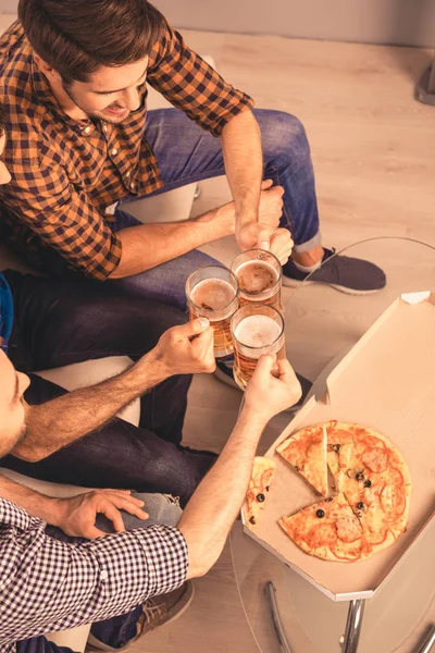 ¡Salud! Vista superior de los hombres con vasos de cerveza y pizza — Foto de Stock