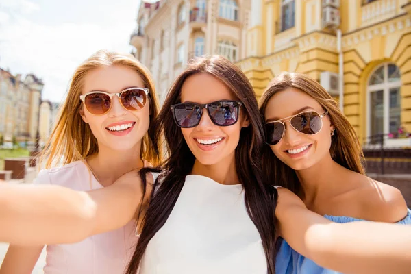 Três namoradas muito sorridentes em óculos fazendo selfie — Fotografia de Stock