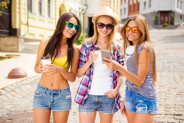 Happy young girl showing photo on her smartphone to her girlfrie — Stock Photo, Image