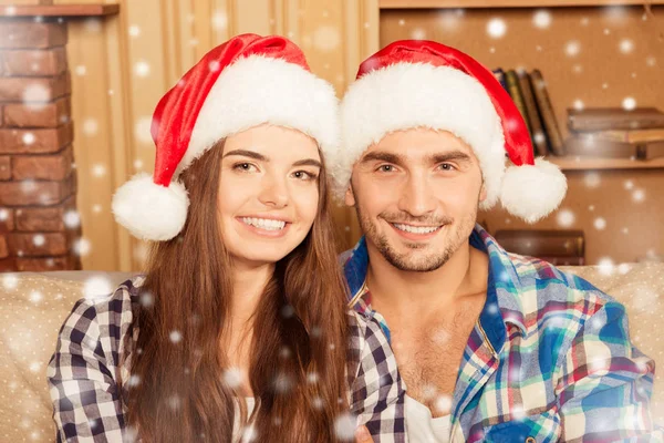 Retrato de jovem feliz e mulher em chapéus de santa — Fotografia de Stock