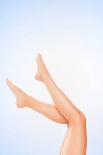 Close up photo of perfect smooth woman's legs on blue background — Stock Photo, Image