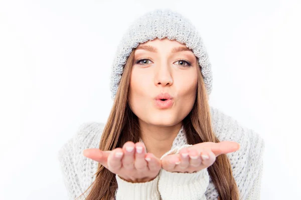 Cheerful woman clothing in warm hat and scarf sending air kiss — Stock Photo, Image