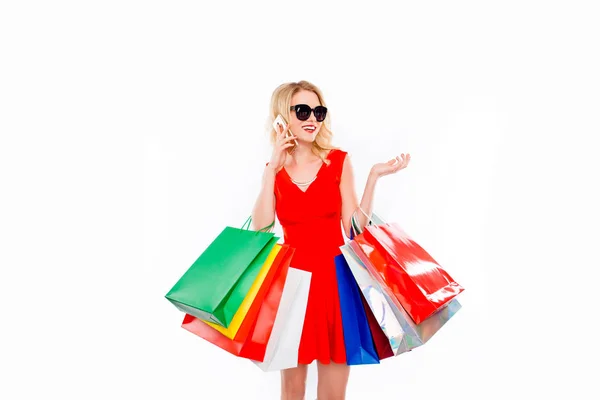 Young woman shopaholic with color paperbags talking on phone — Stock Photo, Image