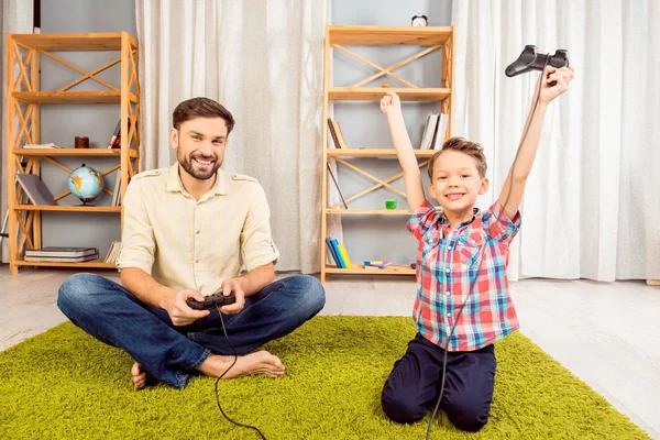 Padre e hijo emocionados jugando videojuegos. feliz niño pequeño ganar — Foto de Stock