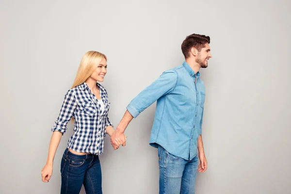 Pareja feliz enamorada cogida de la mano y yendo a alguna parte — Foto de Stock