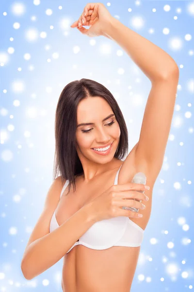 Mulher feliz colocando desodorizante em sua axila no fundo de — Fotografia de Stock