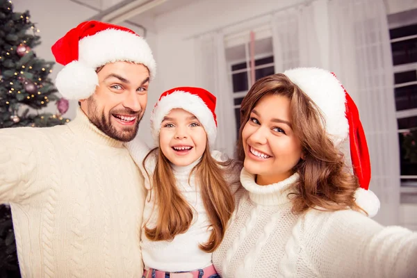 Selfie de Natal de família sorrindo vestindo chapéus de Papai Noel — Fotografia de Stock