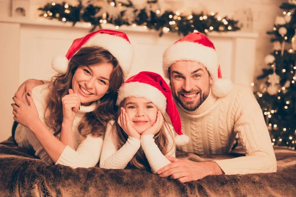 Retrato de família feliz bonito em chapéus de santa no Natal na cama — Fotografia de Stock