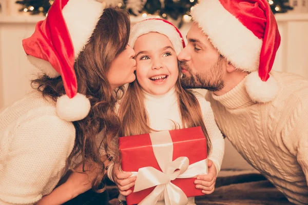 Pais felizes beijando filha e dando xmas presente na cama — Fotografia de Stock