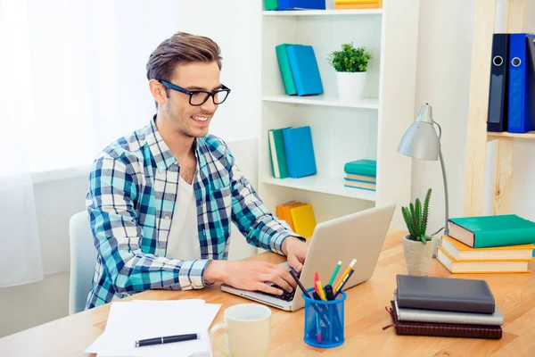 Lächelnder smarter Geschäftsmann mit Brille, der mit Laptop im Büro arbeitet — Stockfoto