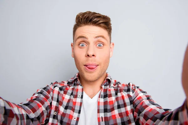 Bello comico uomo mostrando la lingua e facendo selfie — Foto Stock