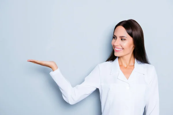 Sorrindo assistente segurando algo na mão e demonstrando i — Fotografia de Stock