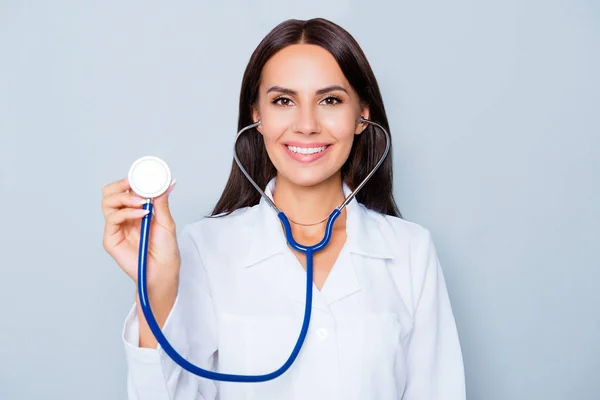 Schöne Gesundheitshelferin mit Stethoskop auf blauem Rücken — Stockfoto